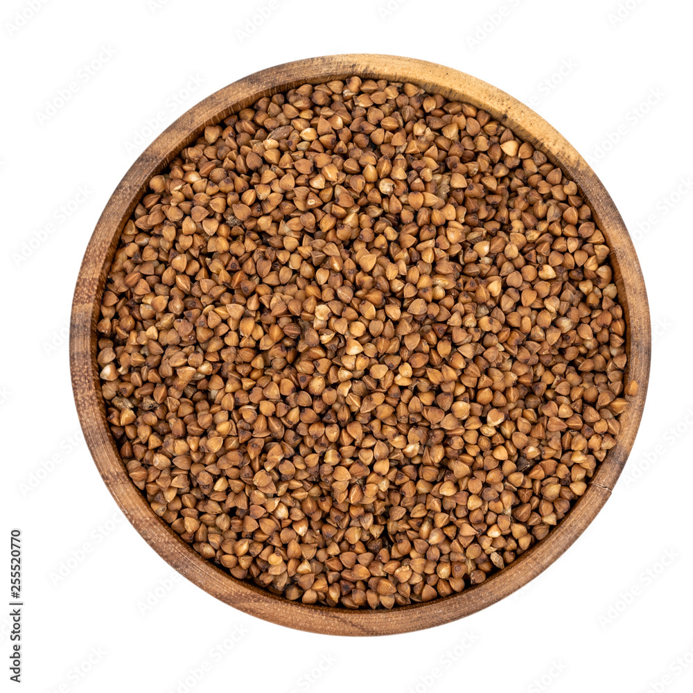 Raw buckwheat in a wooden plate isolated on white background Raw buckwheat in a wooden plate isolated on white background