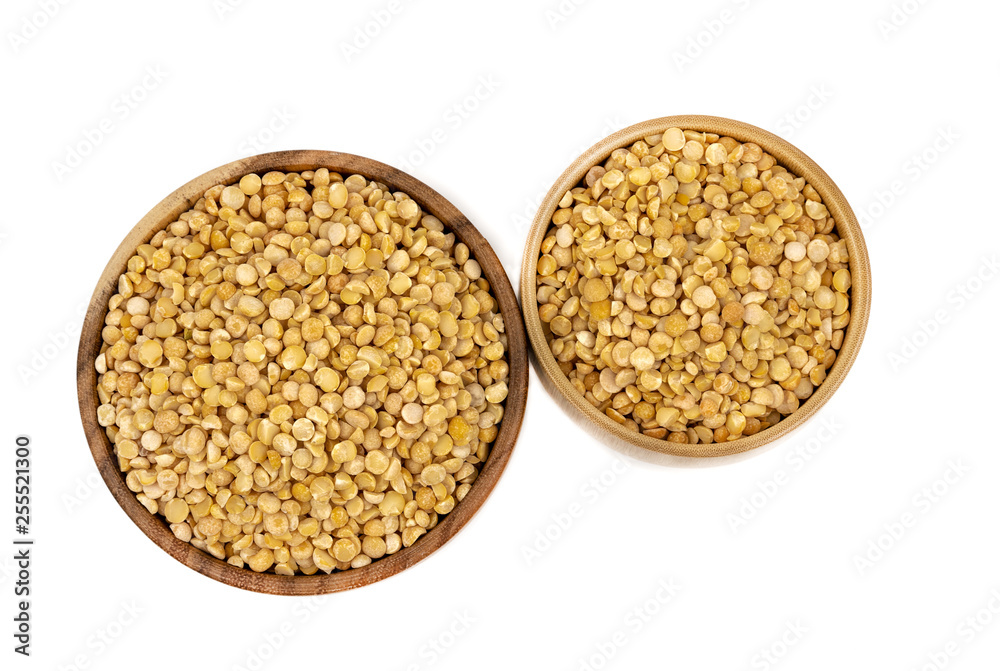 Raw yellow split peas in a wooden plate (bowl) isolated on white background, top down view Raw yellow split peas in a wooden plate (bowl) isolated on white background, top down view
