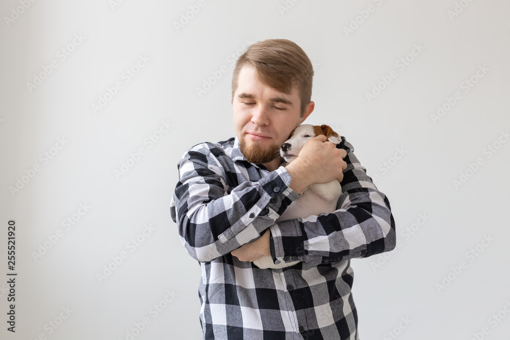 people, pets and animals concept - handsome man holding jack russell terrier puppy on white background people, pets and animals concept - handsome man holding jack russell terrier puppy on white background