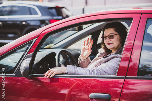 Portrait of plus size woman in red car on city street . Woman driver concept. Mature women lifestyle. Model plus size . XXL model  © T.Den_Team