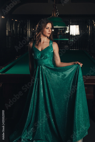 Young woman playing billiards in the dark billiard club © Даниль Шинов