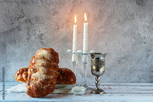 Shabbat Shalom - challah bread, shabbat wine and candles on wooden table photo