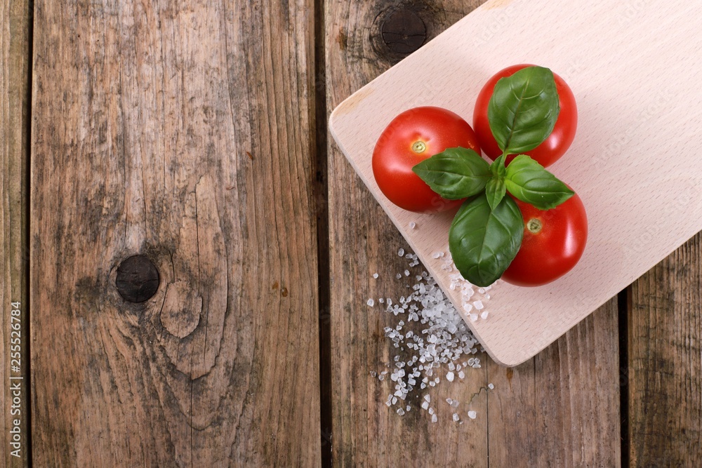 fresh tomatoes with basil and salt on a rustic wooden table - healthy breakfast fresh tomatoes with basil and salt on a rustic wooden table - healthy breakfast
