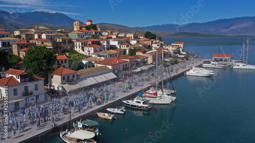 Aerial drone bird s eye view photo of people participating in traditional colourful flour war or Alevromoutzouromata part of Carnival festivities in historic port of Galaxidi  Fokida  Greece