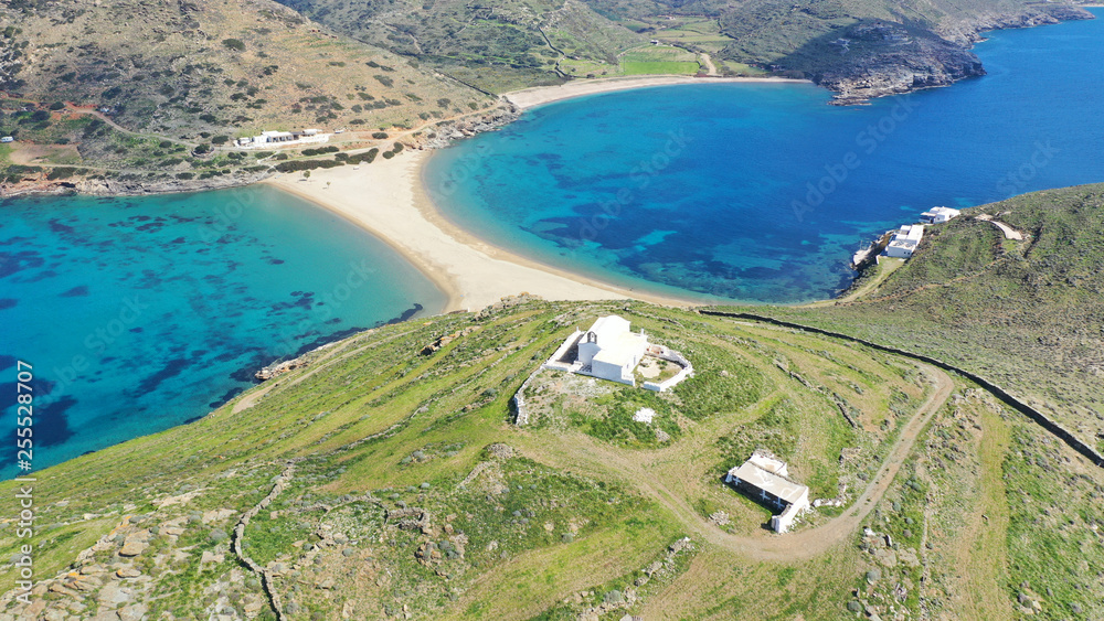 Aerial drone photo of picturesque chapel of Agios Loukas and iconic two sided sandy tropical turquoise sea paradise beach of Kolones and Fykiada in island of Kythnos at spring, Cyclades, Greece