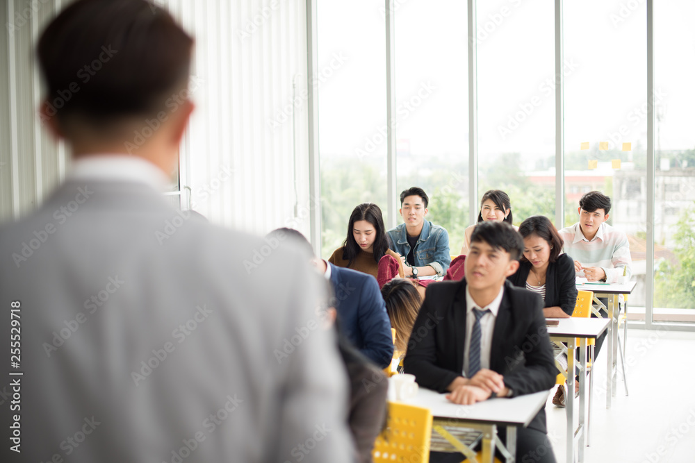 Asian male speaker is speaking at seminars and workshops to the people in the meeting. Participants are raising their hands to ask questions. Asian male speaker is speaking at seminars and workshops to the people in the meeting. Participants are raising their hands to ask questions.