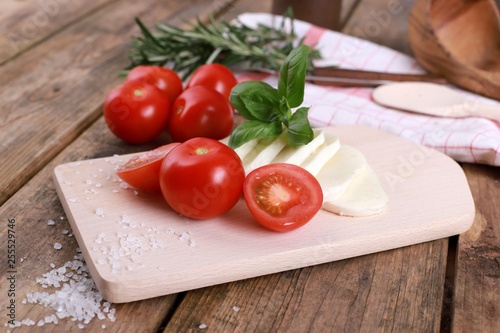 tomato mozzarella - fresh tomatoes with mozzarella cheese and basil  on a rustic wooden table - healthy breakfast