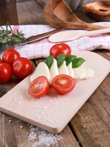 tomato mozzarella - fresh tomatoes with mozzarella cheese and basil on a rustic wooden table - healthy breakfast