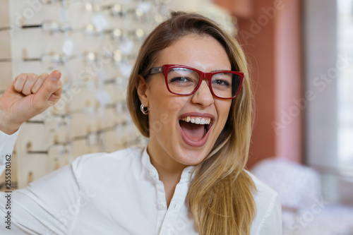 Fototapeta Naklejka Na Ścianę i Meble -  portrait of happy woman wearing glasses in optic store