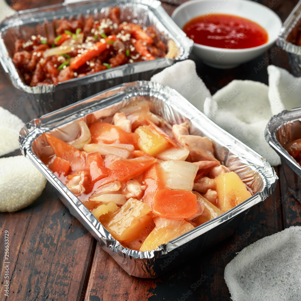 Chinese takeaway food. Crispy shredded beef, sweet and sour chicken wings, egg noodles with bean sprouts, pineapple, chilli dip and prawn crackers