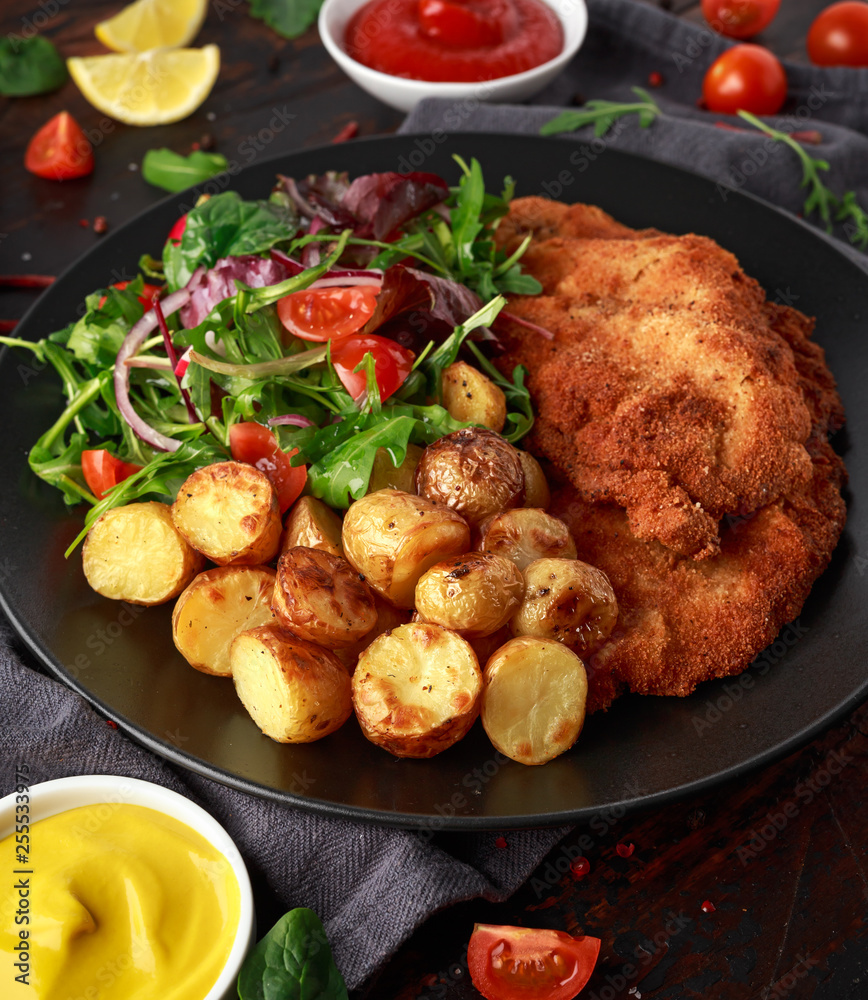 Homemade breaded pork schnitzel with roast potato and vegetables Homemade breaded pork schnitzel with roast potato and vegetables