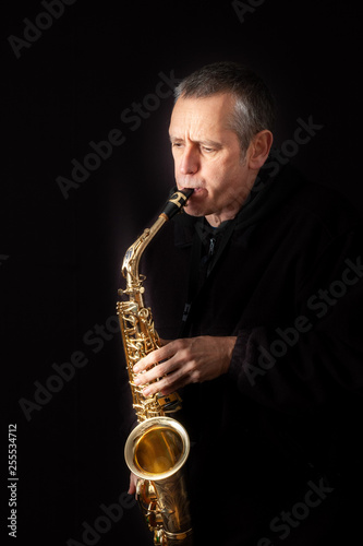 Canvas Print A Musician playing jazz music on his saxophone, on black background