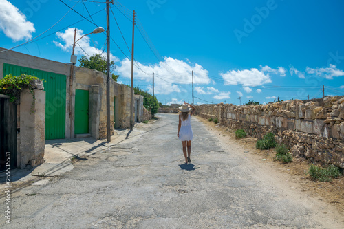 Śliczna kobieta idzie pustą ulicą w ciepłym kraju photo