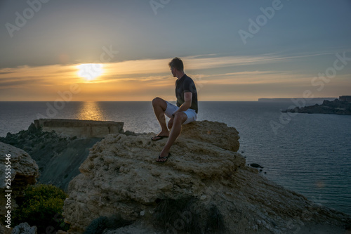 Facet siedzi na skale