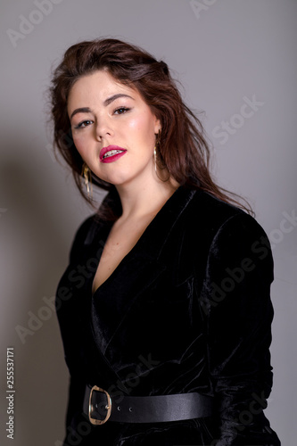 Beautiful elegant sexy brunette diva woman portrait in black clothes on grey background