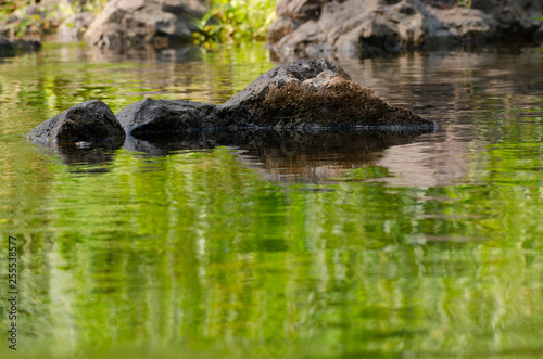 River flowing around the smooth rocks. Taken at Khlong Lan Waterfall Kamphaeng Phet Province, Thailand.