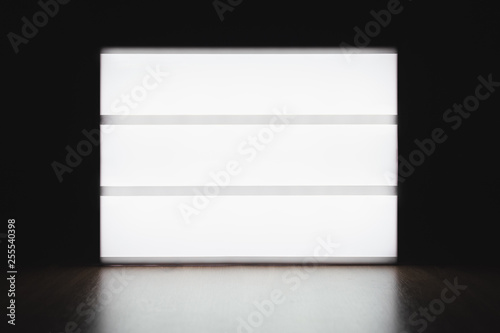 Mock up lightbox luminous display without letters on the table in the dark