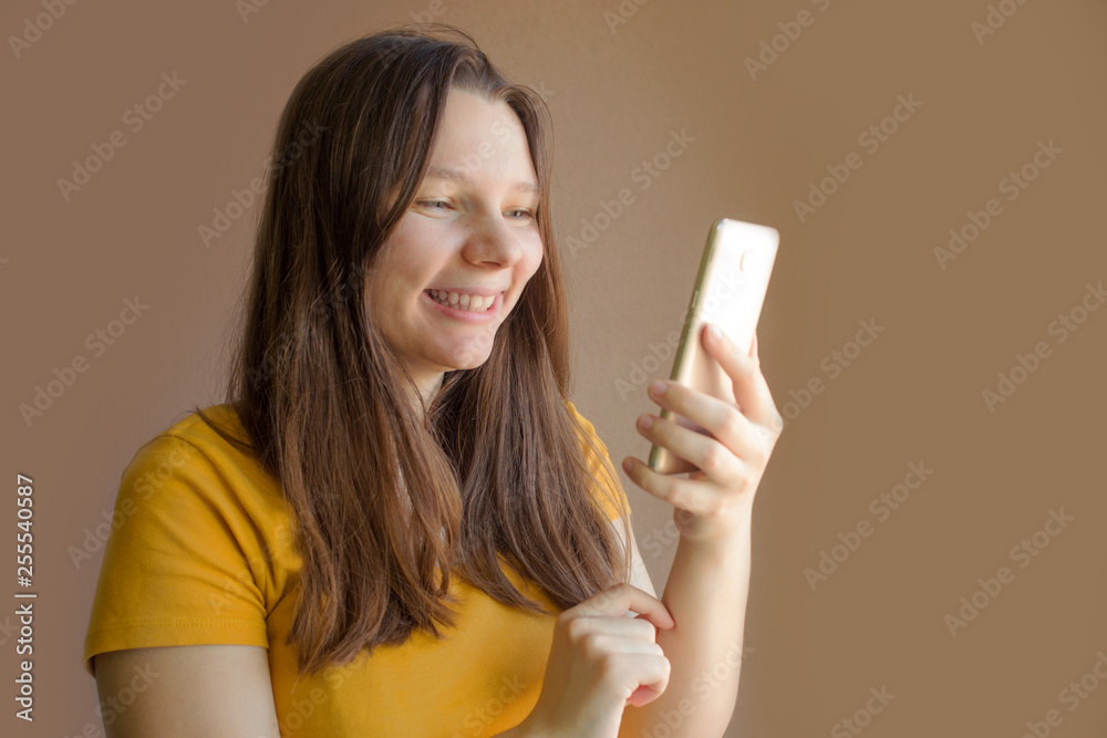 technology concept - smiling young woman in blank yellow t-shirt using smartphone technology concept - smiling young woman in blank yellow t-shirt using smartphone