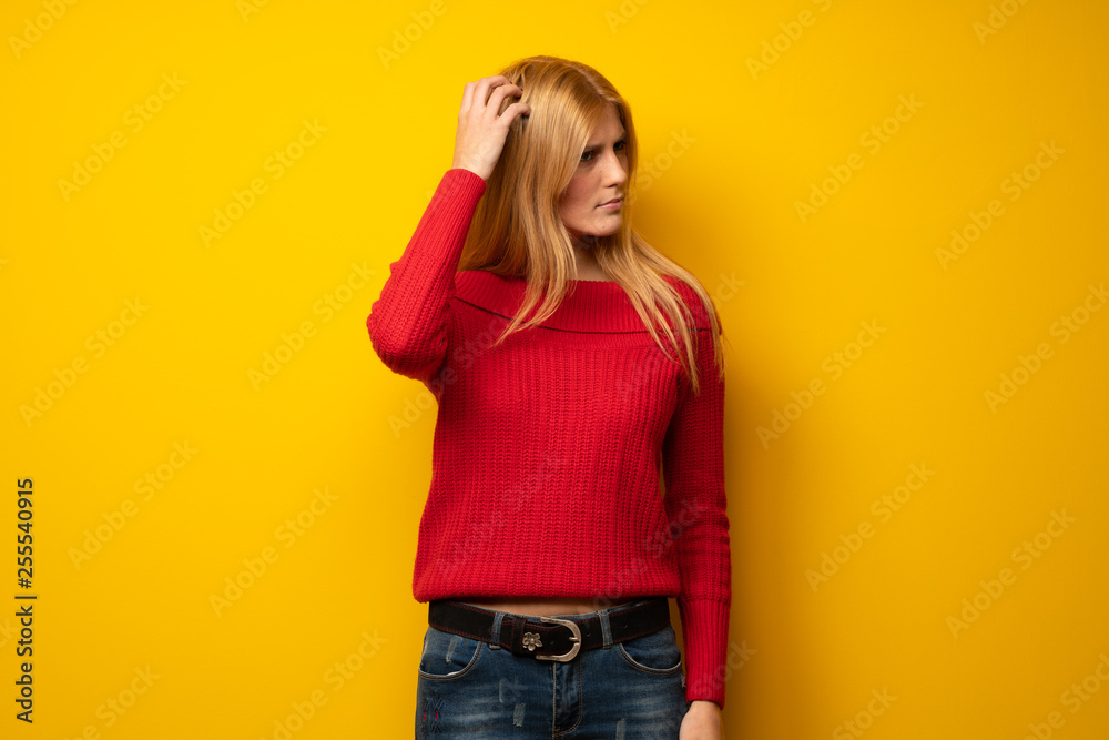 over yellow wall having doubts while scratching head over yellow wall having doubts while scratching head