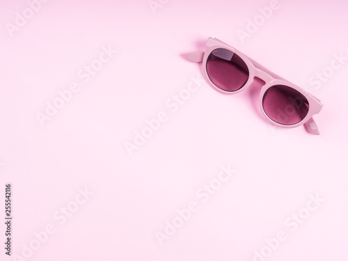 Pink sun glasses on monochrome backdrop