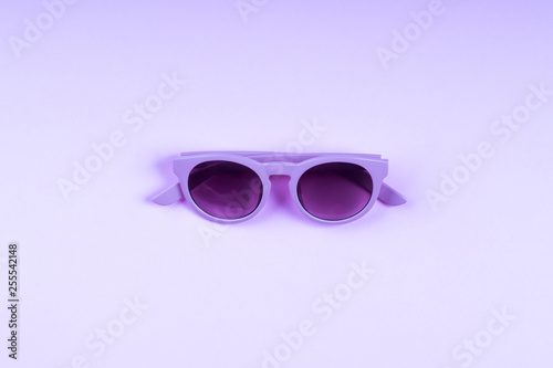 Ultra violet sun glasses on monochrome backdrop