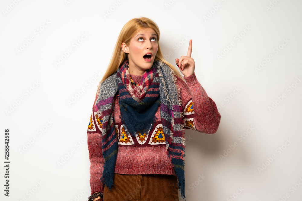 Hippie woman over white wall intending to realizes the solution while lifting a finger up