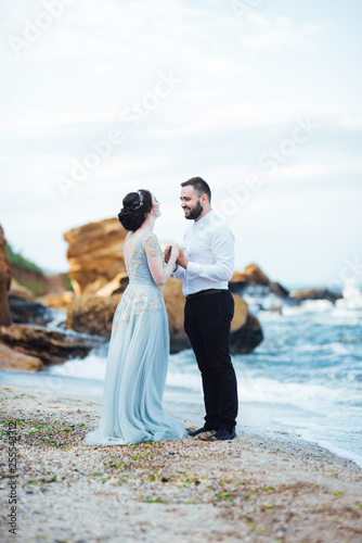 same couple with a bride in a blue dress walk