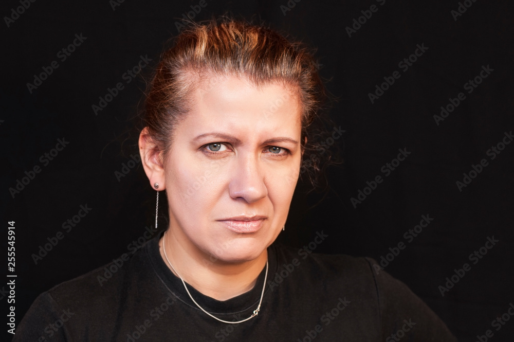 Obraz premium Portrait of beautiful woman on black background. A woman has a sad face because her hair begins to become gray
