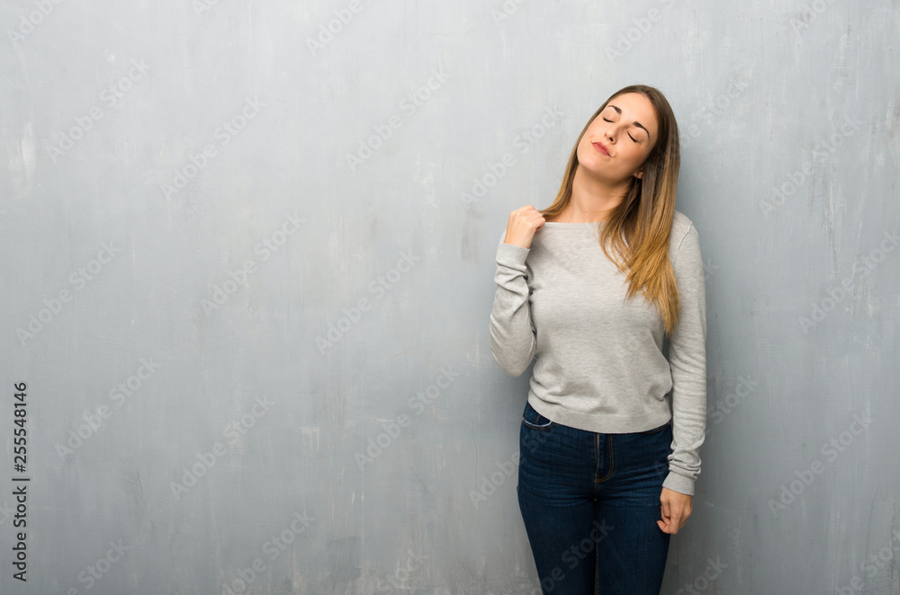 Young woman on textured wall with tired and sick expression Young woman on textured wall with tired and sick expression