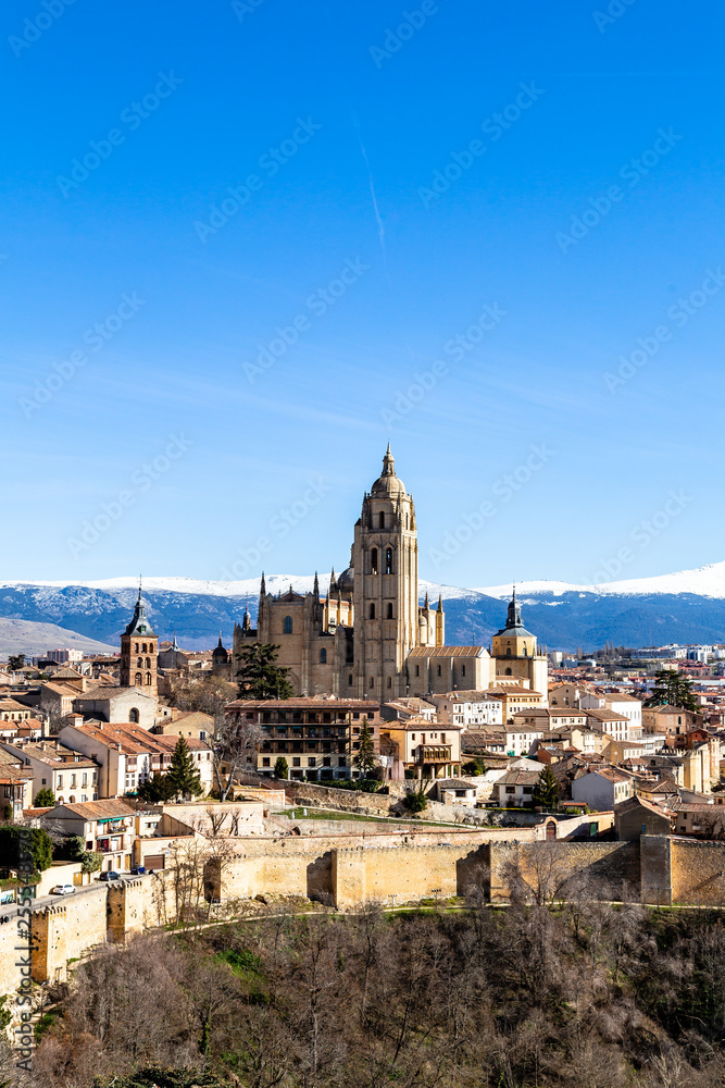 Segovia, Spain – View from Juan II tower in Winter time of the Alcazar of the old town of Segovia and the Cathedral with the snow capped Sierra de Guadarrama behind