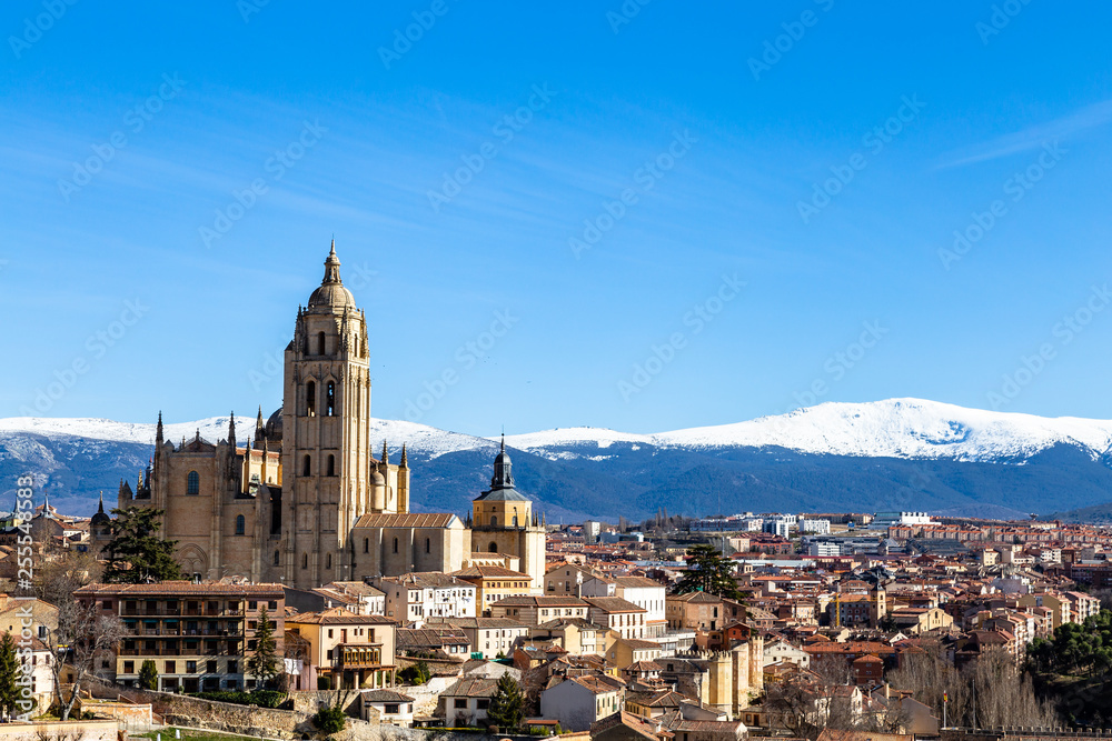 Segovia, Spain – View from Juan II tower in Winter time of the Alcazar of the old town of Segovia and the Cathedral with the snow capped Sierra de Guadarrama behind