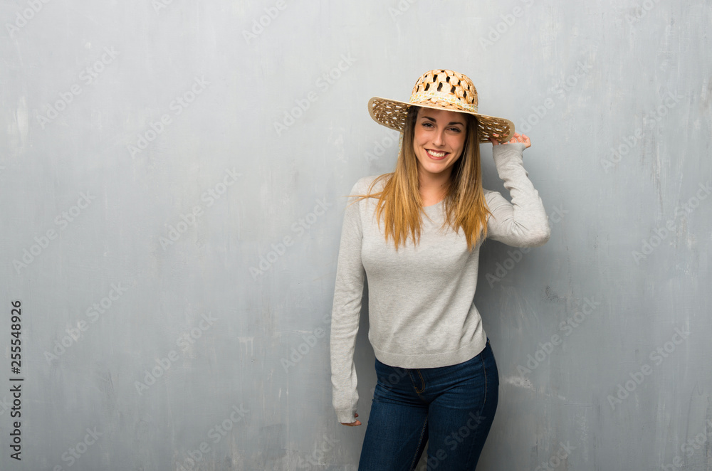 Young woman on textured wall with hat Young woman on textured wall with hat