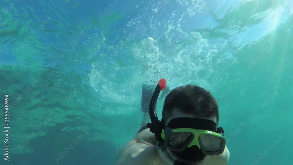man in snorkeling mask and snorkel swimming underwater sea and shooting selfie video. Man snorkeling in mask and snorkel under transparent sea water. man in snorkeling mask and snorkel swimming underwater sea and shooting selfie video. Man snorkeling in mask and snorkel under transparent sea water.