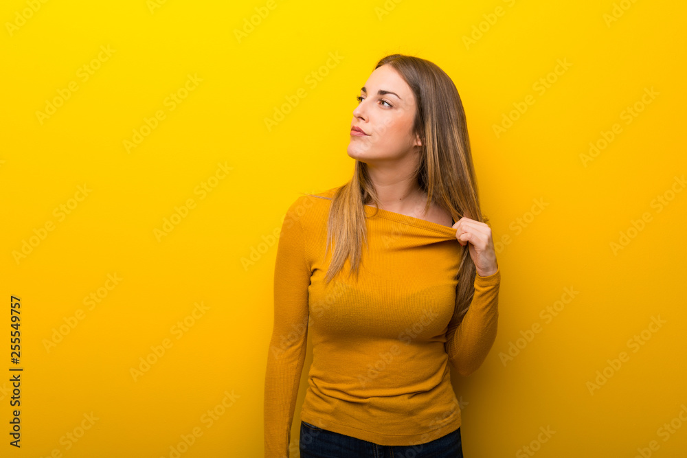 Young woman on yellow background with tired and sick expression