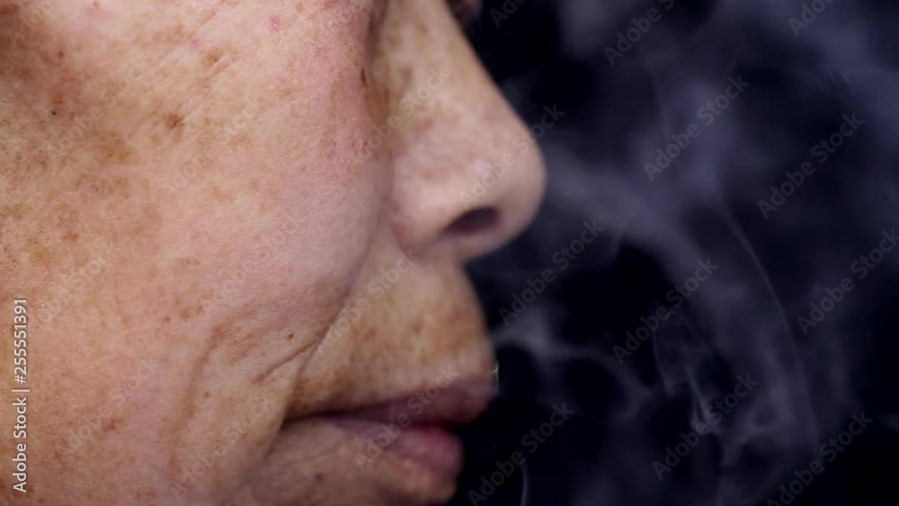 An elderly Chinese woman smokes An elderly Chinese woman smokes