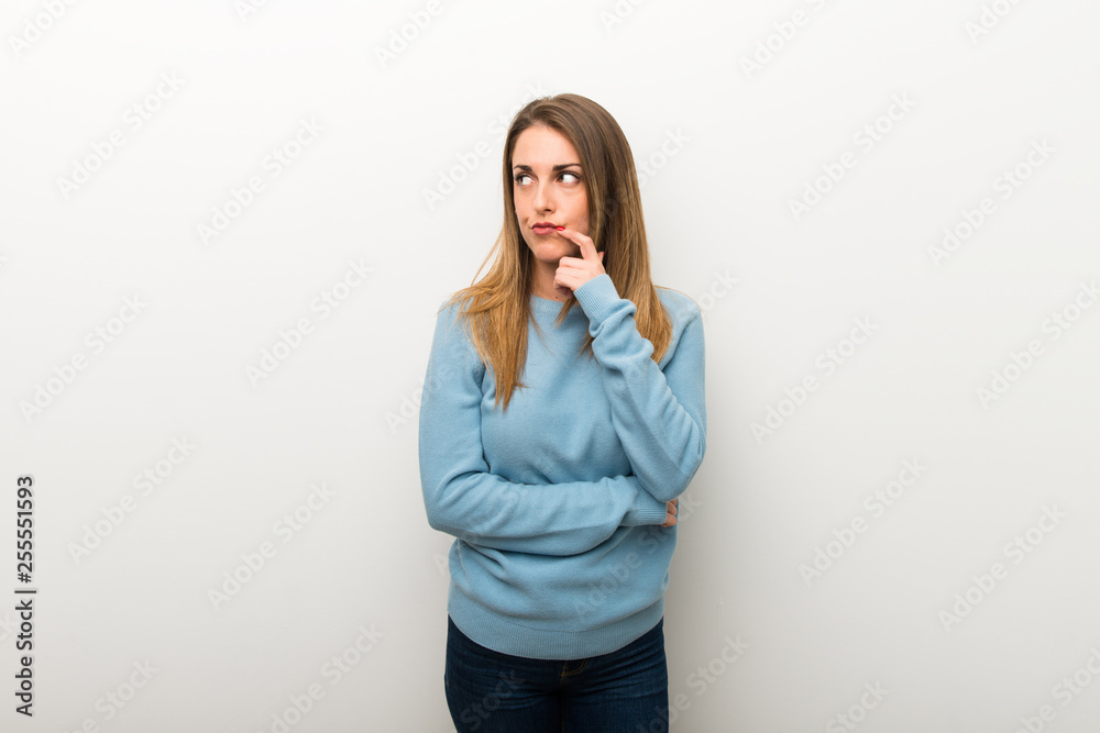 Blonde woman on isolated white background having doubts while looking up Blonde woman on isolated white background having doubts while looking up