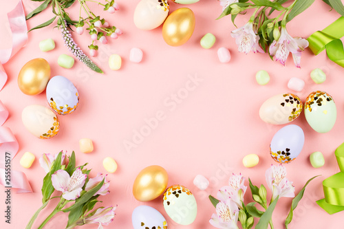 Festive Happy Easter background with decorated eggs  flowers  candy and ribbons in pastel colors on pink. Copy space