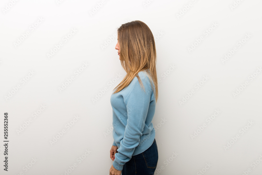 Blonde woman on isolated white background in lateral position Blonde woman on isolated white background in lateral position