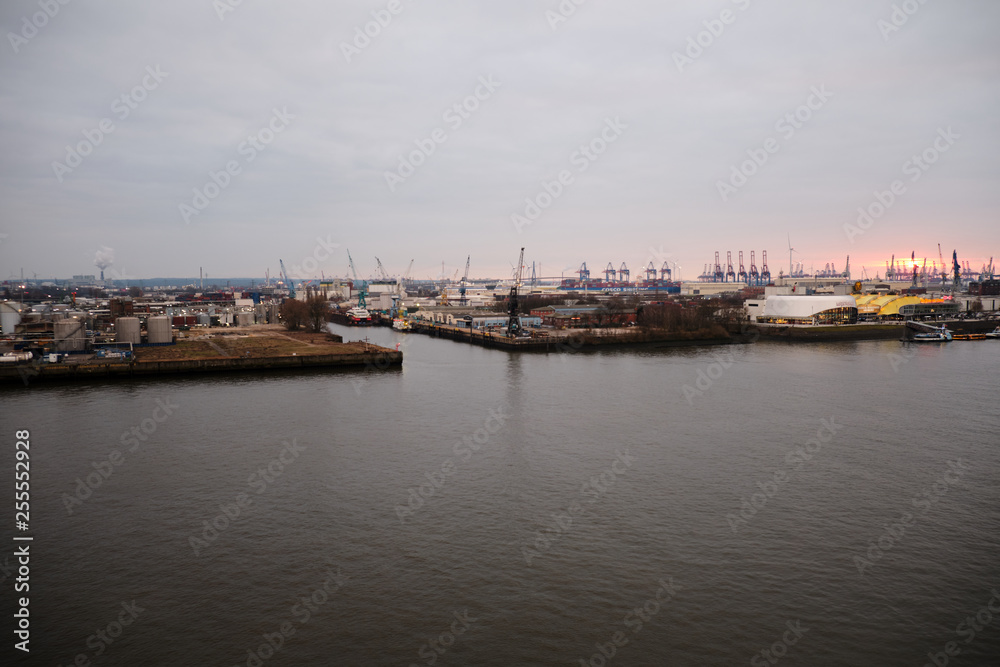 Hamburg Harbor with beautiful sunset and loading cranes
