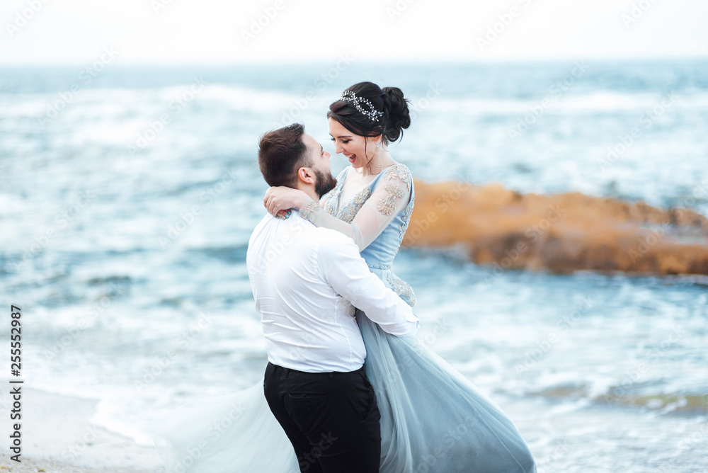 same couple with a bride in a blue dress walk