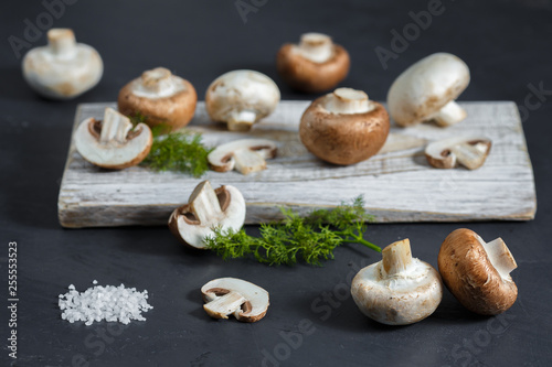 Composition with fresh champignon mushrooms on wooden board. Rustic style