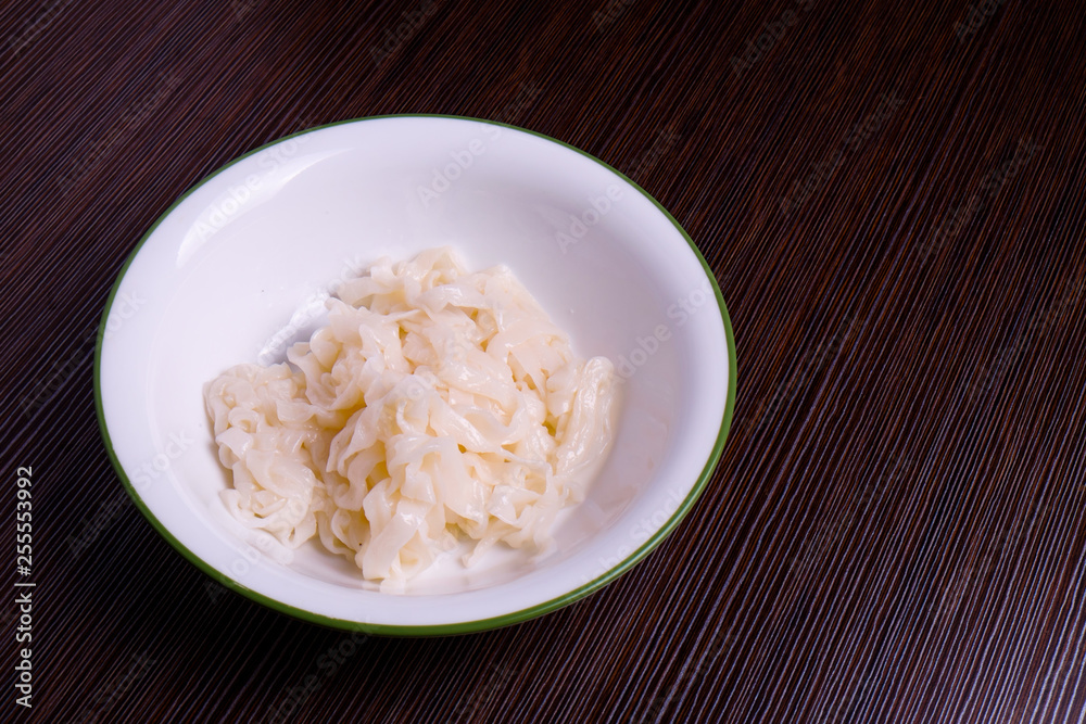 Kuey teow in a white bowl on the table Kuey teow in a white bowl on the table
