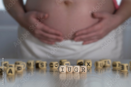 Abbreviation IUGR for intrauterine growth restriction composed of wooden letters.