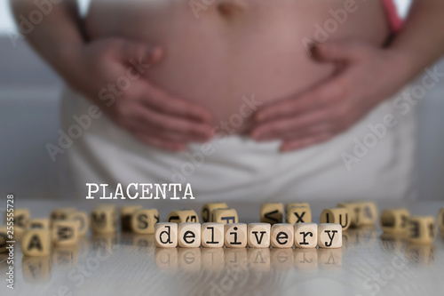 Words PLACENTA DELIVERY composed of wooden letters.