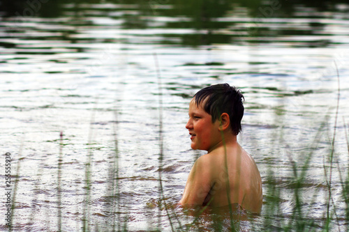 Fototapeta Naklejka Na Ścianę i Meble -  Happy boy having fun in pond.