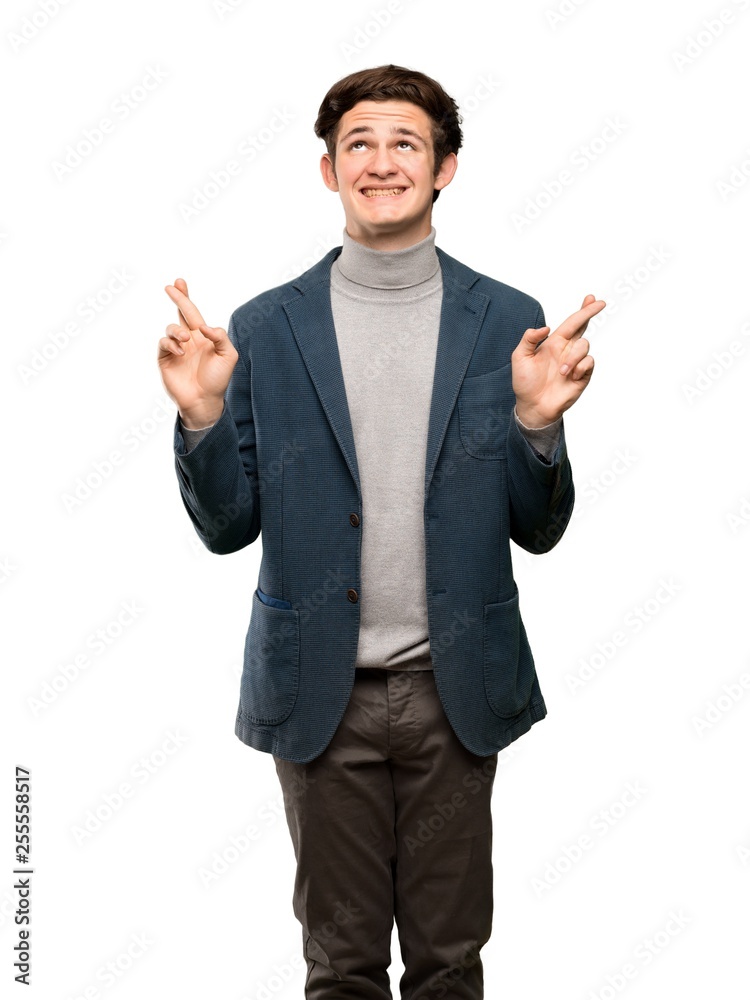 Teenager man with turtleneck with fingers crossing and wishing the best over isolated white background Teenager man with turtleneck with fingers crossing and wishing the best over isolated white background