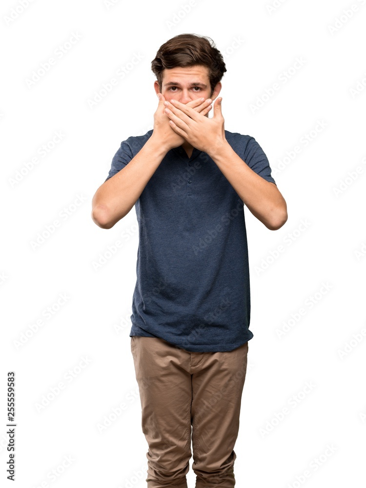 Teenager man covering mouth with hands for saying something inappropriate over isolated white background Teenager man covering mouth with hands for saying something inappropriate over isolated white background