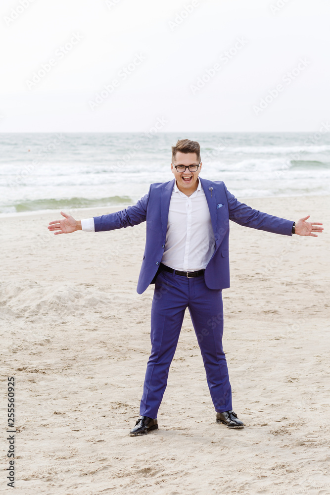 portrait of stylish groom in blue suit on the beach portrait of stylish groom in blue suit on the beach