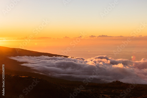 Incredible sunset landscape in the mountains. Clouds lie on the mountainside