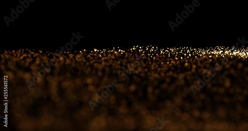 Gold star animation. Abstract golden waving glowing sparkle dots, with alternating focus point. Gold glitter particle elements on black background.